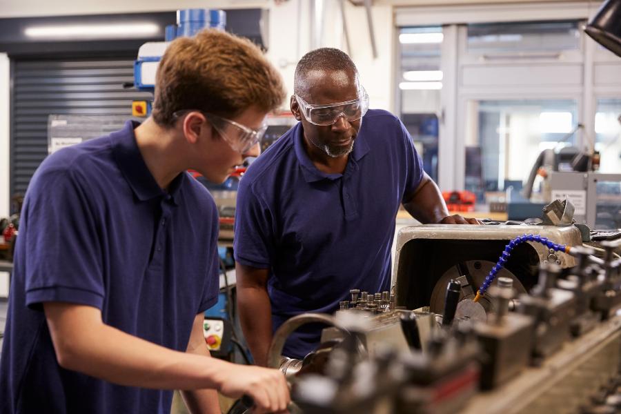 16-18 young man at factory working with older man